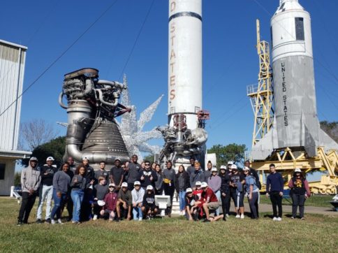 Picture of ATOM students in front of NASA rockets